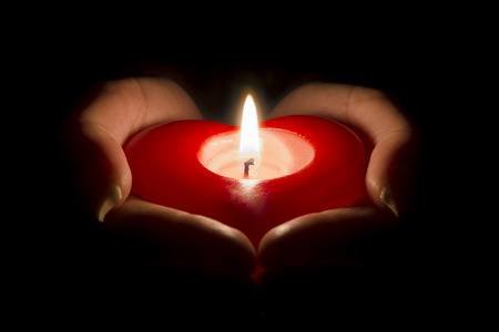 69894242-mains-de-la-femme-tenant-une-bougie-en-forme-de-coeur-dans-le-noir.jpg